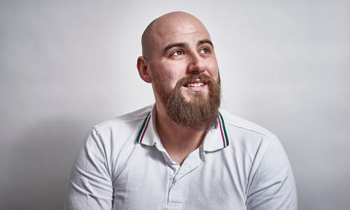 A male with a positive expression on his face, looking up and slightly away from the camera