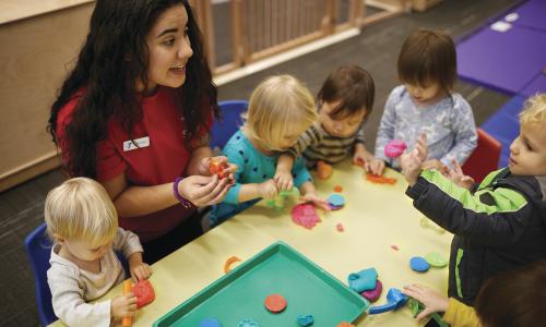 YMCA staff member engaging a group of kids in an activity