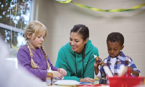 Child care staff doing arts and crafts with children
