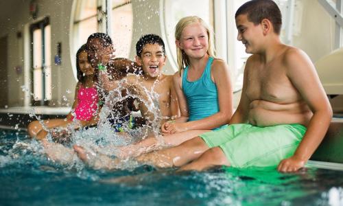 stock photo of children at the pool splashing feet in water