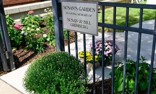 Image shows dedication sign on a gate around the new garden at the Lakewood Family YMCA, sign reads: "Susan's Garden, In loving memory of Susan and Bill Grimberg"
