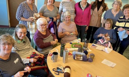 Caps and Laps participants knitting together