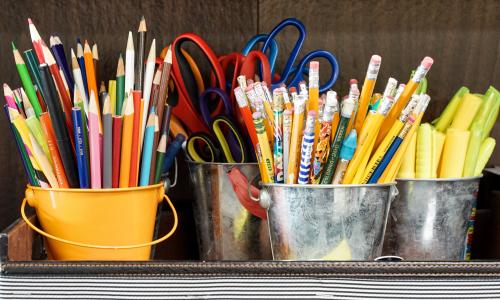 Pens, pencils, highlighters, and scissors in buckets