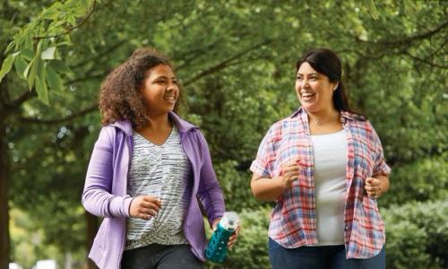 Two women walking and talking in a park