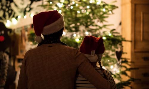 Mother and daughter sitting in front of a Christmas Tree