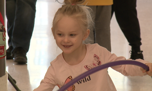 Child smiling and playing with a hula-hoop at Healthy Kids Day