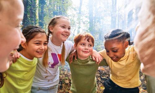 YMCA Camp counselor huddles with campers