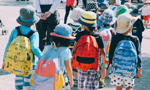 Children wearing backpacks on their way to school