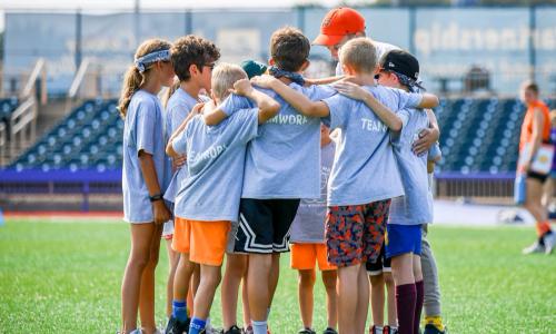 Summer camp kids huddle together