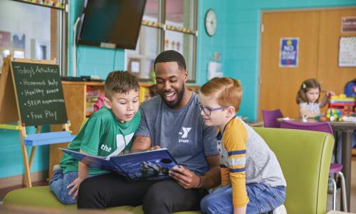 YMCA camp staff reads to camp members