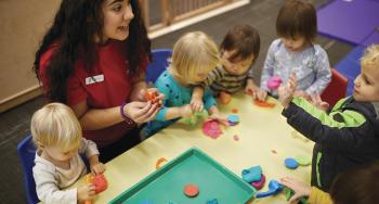 YMCA staff member engaging a group of kids in an activity