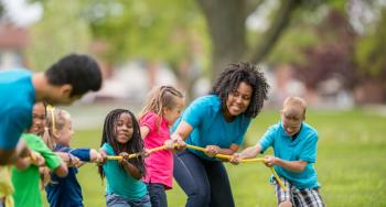 Counselors and campers playing tug of war