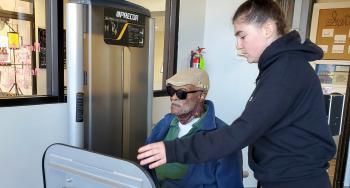 Hillcrest YMCA member, Henry Butler, using leg press machine with assistance by trainer, Sami Carouso-Taylor