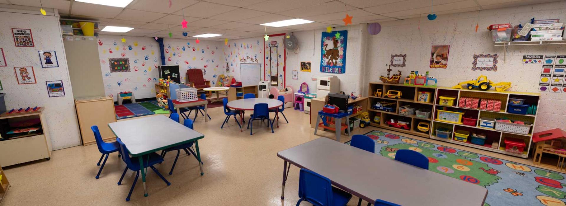 Child Watch area with tables, games, toys, and learning posters