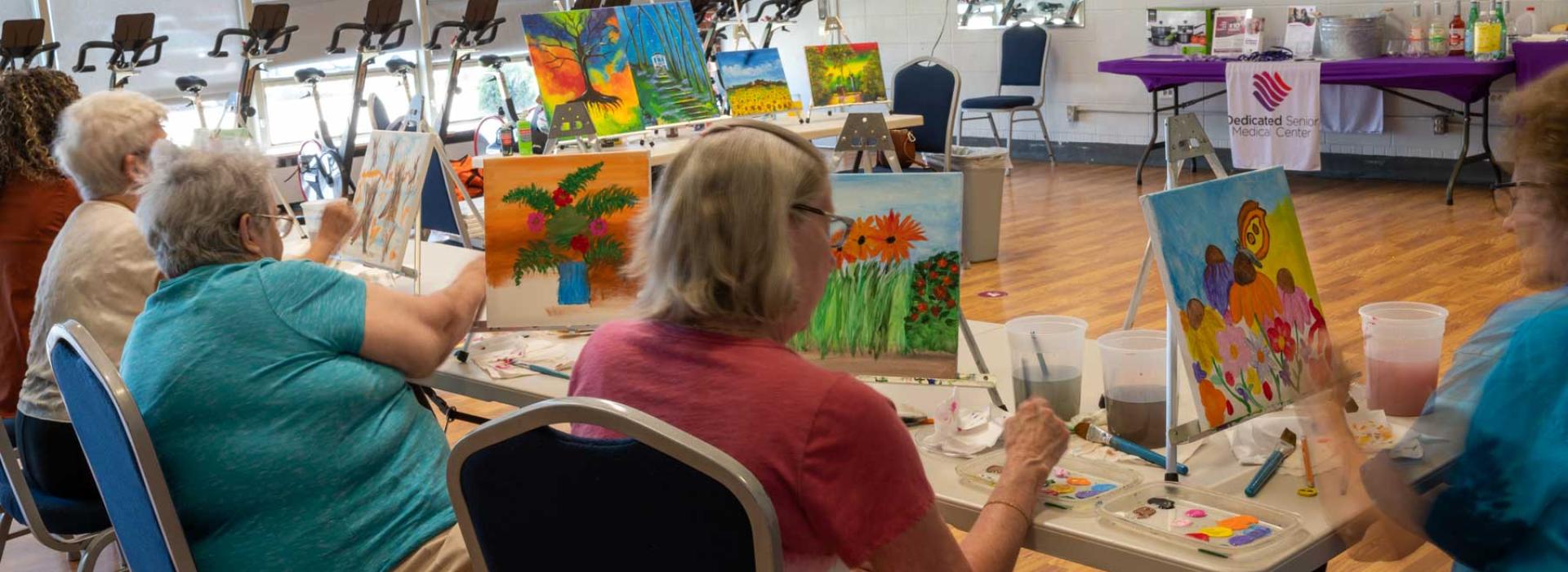 Image shows the YMCA Active Older Adults (AOA) group participating in a group painting activity